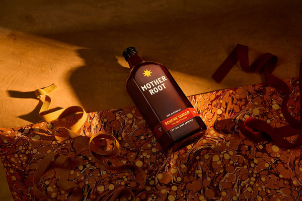 Bonfire Ginger bottle lying on marbled paper with ribbon